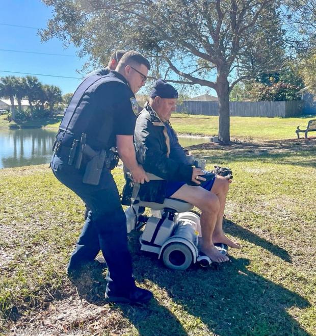 경찰이 할아버지를 구조한 후 고장난 휠체어를 밀고 있다. [출처: 포트 세인트 루시 경찰서 페이스북]