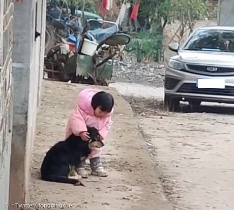 어린 아이가 폭죽 소리를 듣고 검은 개의 양쪽 귀를 고사리 손으로 감쌌다. [출처: Twitter/ tongbingxue]